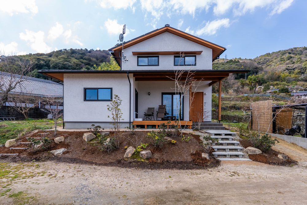 山を背にした住宅地に建つ木造二階建ての家の外観